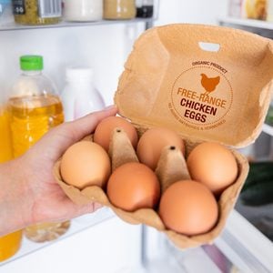 Woman holding package of free range chicken eggs