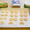 Butter, lard and shortening behind a tray of pie crust pieces the shape of cookies